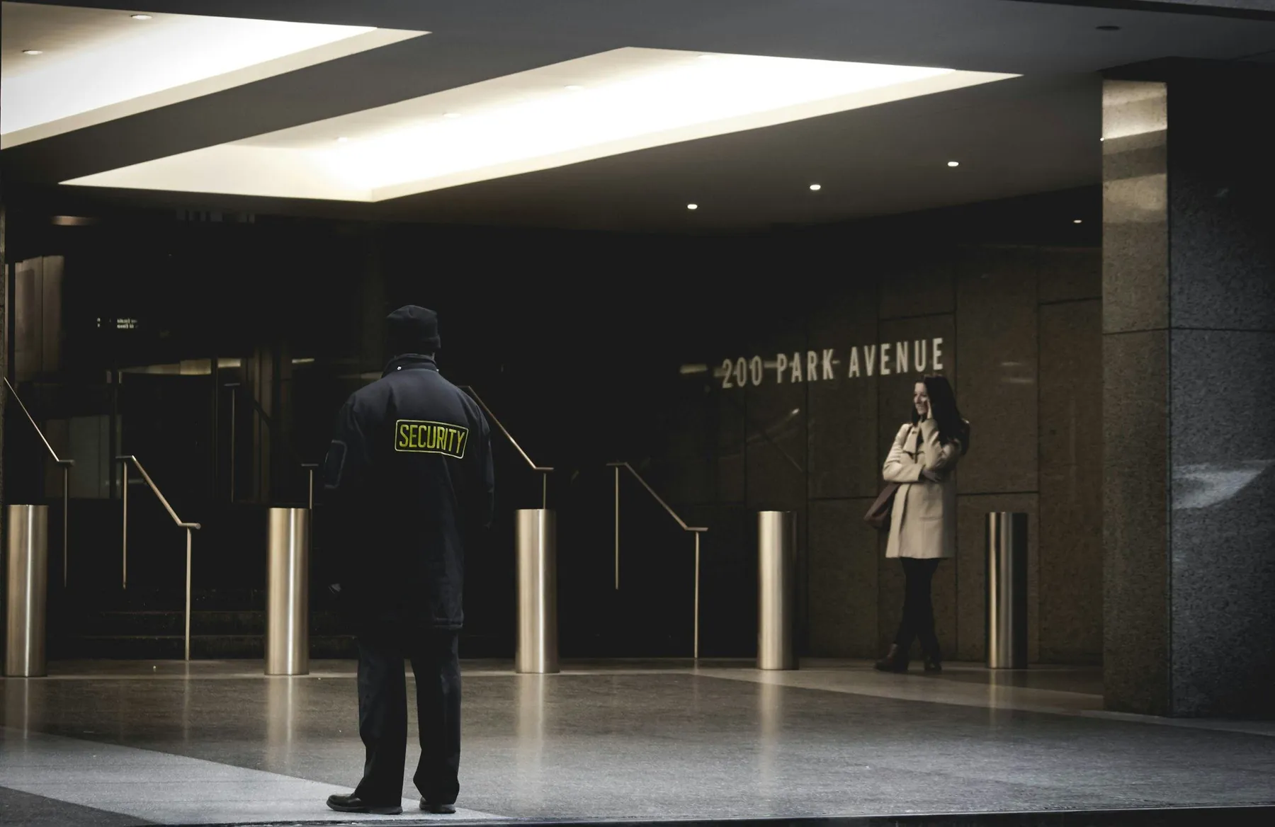 Sicherheitsmitarbeiter in der Eingangshalle eines Bürogebäudes bei Nacht