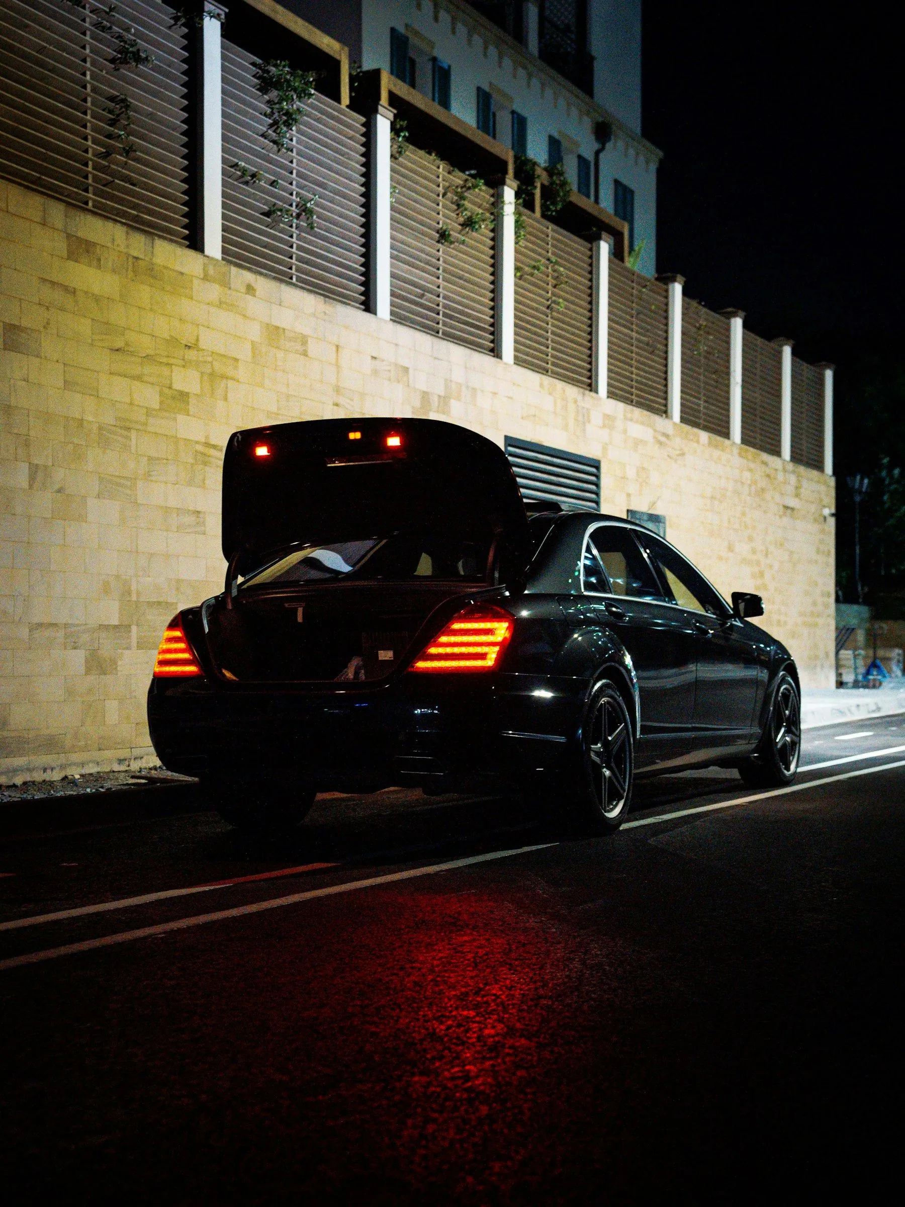 Limousine mit geöffnetem Kofferraum bei Nacht